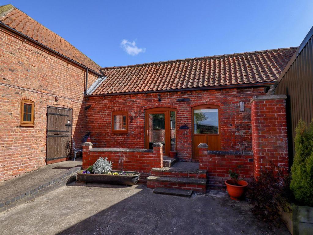 a red brick house with a door and stairs at Ticklepenny in Louth