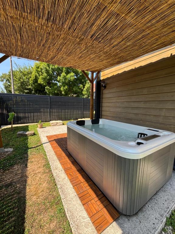 a hot tub on a patio under a roof at Chalet Des Aigrettes- Jacuzzi privatif in Chassey-lès-Montbozon