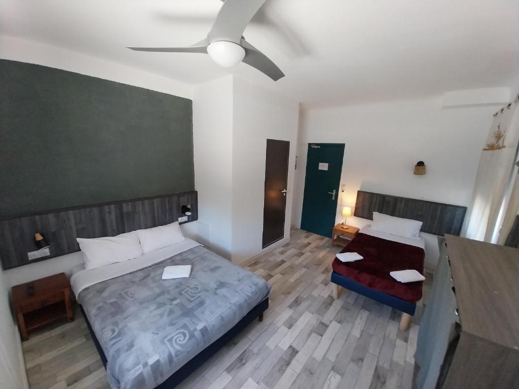 a bedroom with two beds and a ceiling fan at Ô & Cimes in Saint-Pierre-dʼAlbigny