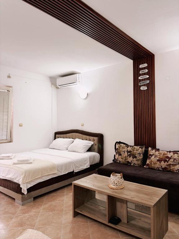 a bedroom with a bed and a couch and a coffee table at Mir & More in Budva