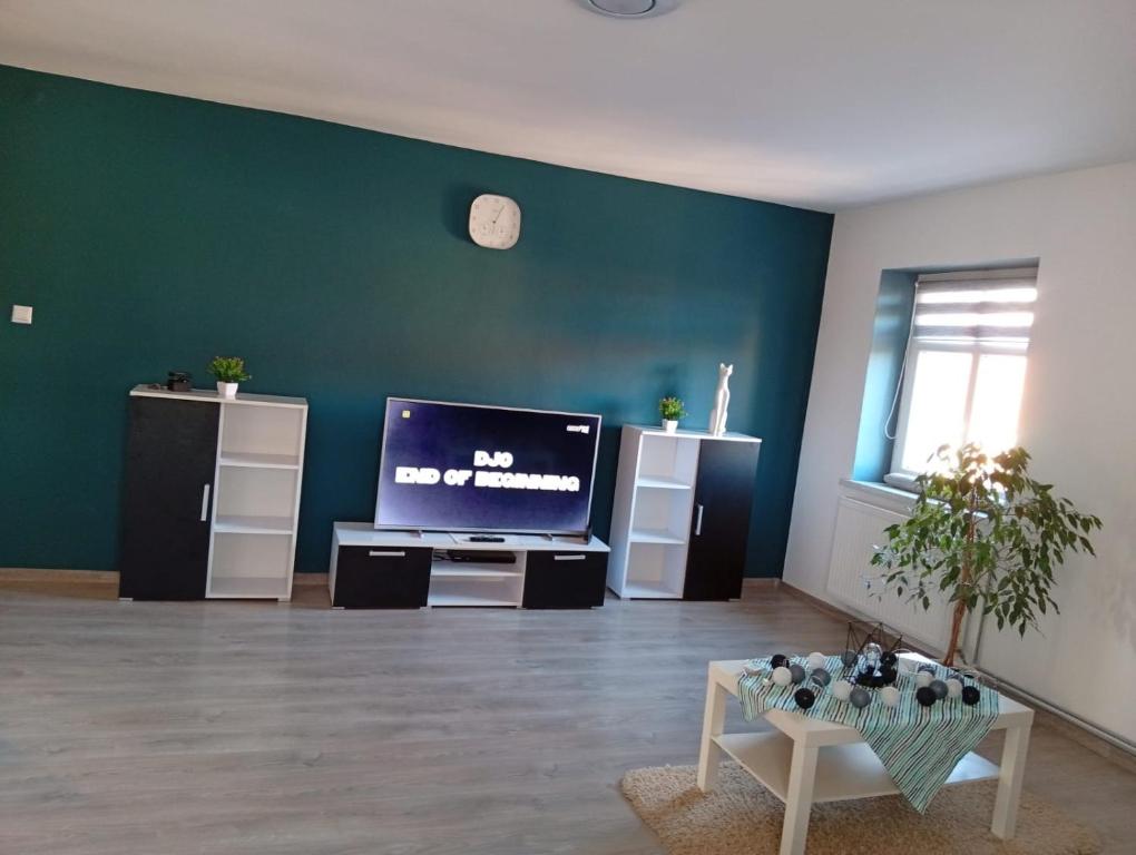 a living room with a flat screen tv on a green wall at Ewula in Giżycko