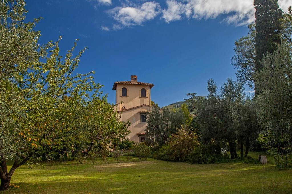 a building in the middle of a field with trees at Villa Il Paradisino in Sesto Fiorentino
