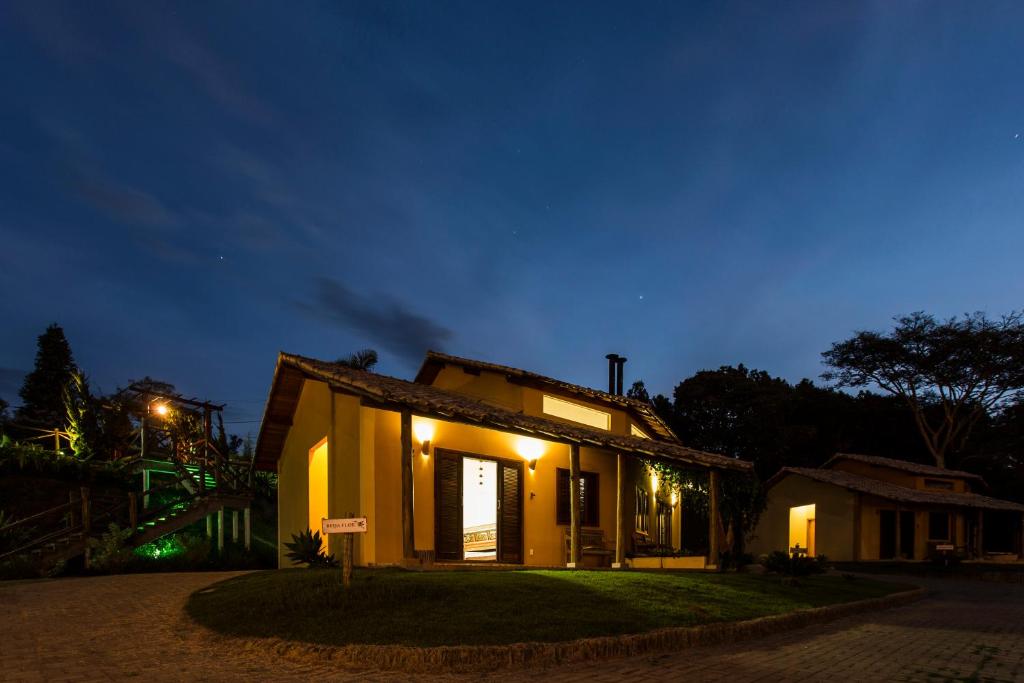 a small house at night with lights on at Vila Chico in São Lourenço