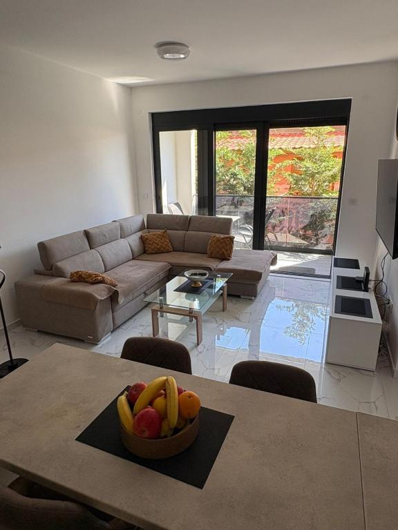 a living room with a table with a bowl of fruit on it at Ivanovica in Đenovići