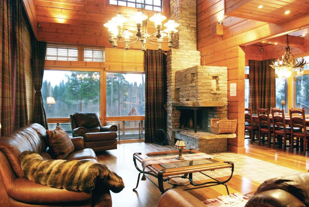 a living room with a couch and a fireplace at KULAUS in Tahkovuori