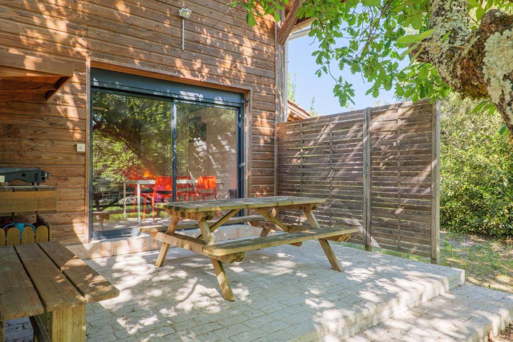 a picnic table in front of a wooden wall at Mas du soleil levant in Les Vans
