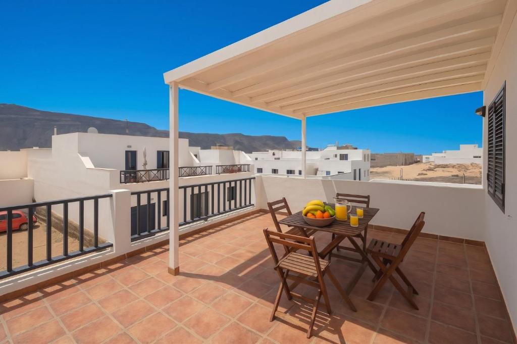 a patio with a table and chairs on a balcony at GuestReady - Marea La Graciosa relax para familias in Caleta de Sebo
