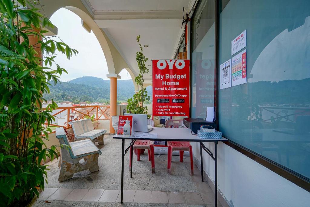 a room with a table and chairs on a balcony at Hotel O My Budget Home in Batu Ferringhi