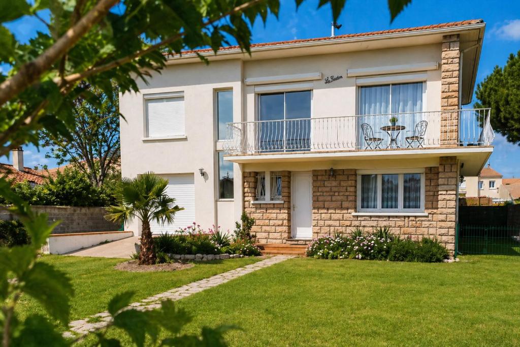 a house with a balcony and a yard at Villa climatisée, proche mer, 2 grands appartements indépendants, parking, WIFI in Le Grau-dʼAgde