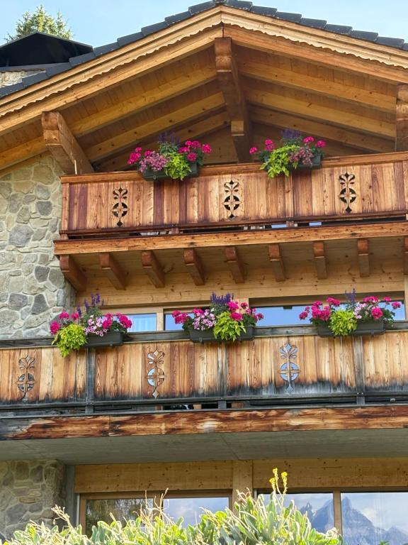 a wooden balcony with flowers on a house at Chalet La Renarde in Villars-sur-Ollon