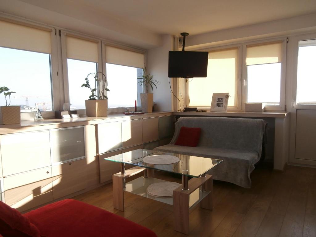 uma sala de estar com um sofá e uma mesa de vidro em Alma Apartments em Varsóvia