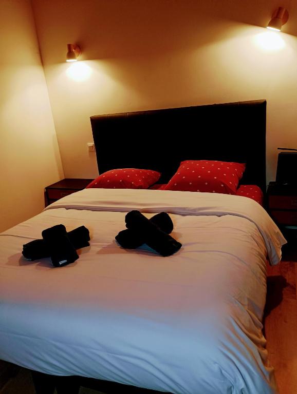 a bedroom with a bed with two hats on it at Chalet lac Celinda in Saint-Mamet