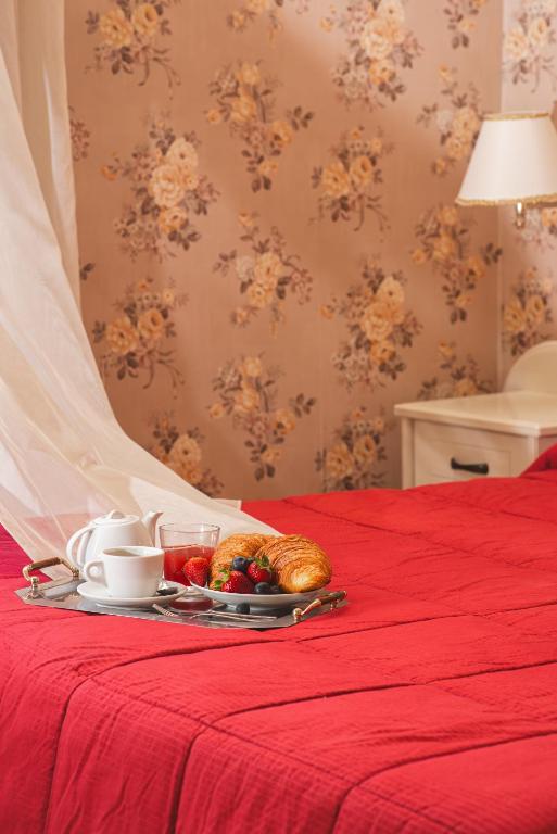 a tray with a plate of food on a bed at Palazzo Riario in Viterbo