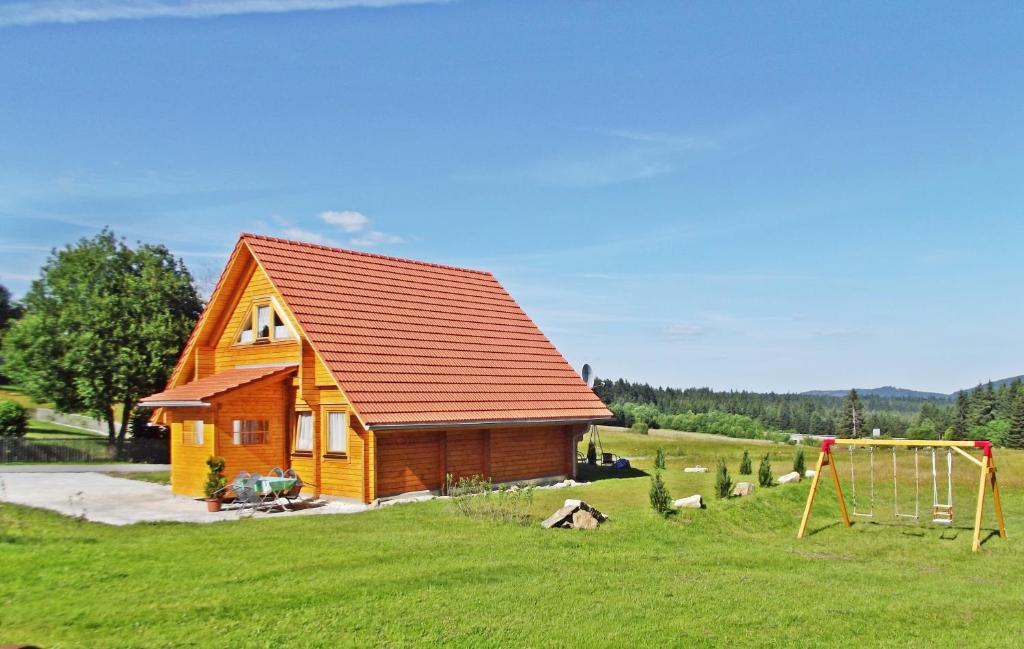 una pequeña casa en un campo con un columpio en Bayerwaldblockhaus en Philippsreut