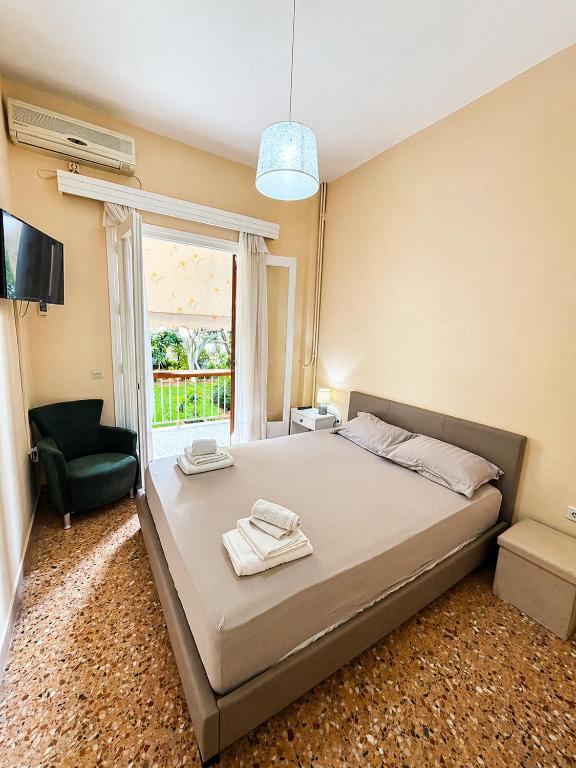 a bedroom with a bed and a chair and a window at Konstantinou Apartments in Paralio Astros