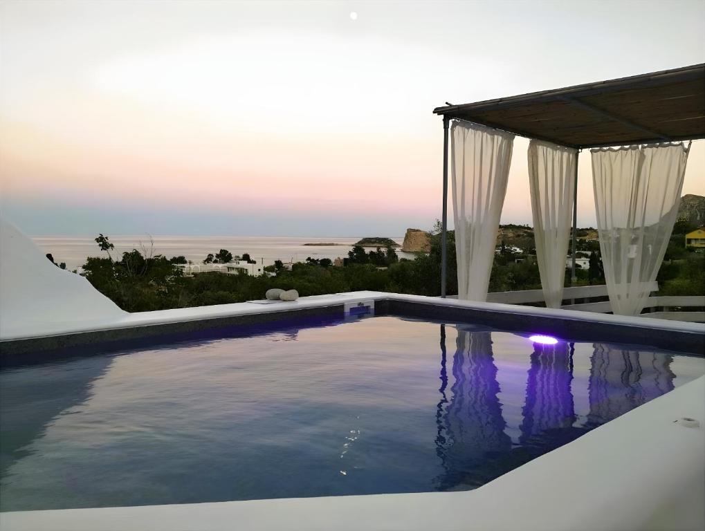 a swimming pool with a view of the ocean at Filia Bungalow in Archangelos