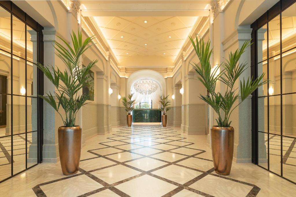 a hallway with two potted plants in a building at EST Hotel Palais Chotek NEW OPENING in Vienna