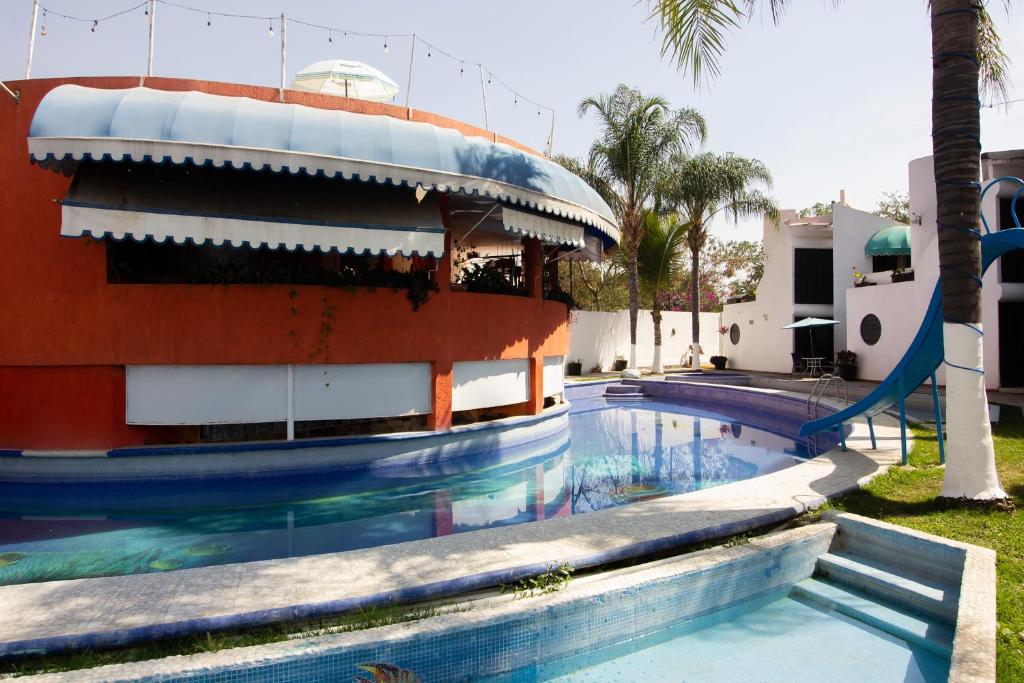 ein Schwimmbad mit Rutsche vor einem Gebäude in der Unterkunft Capital O Hotel Partidor Del Sol, Oaxtepec in Oaxtepec