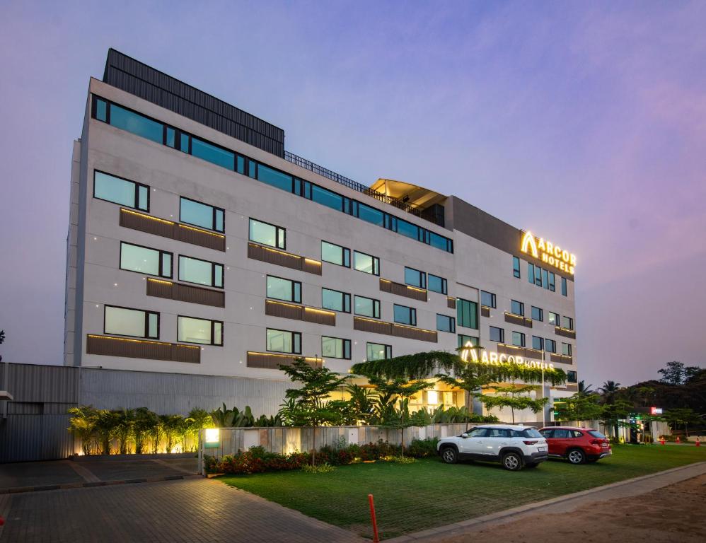 a building with a car parked in front of it at Arcor Hotels Mysuru in Mysore
