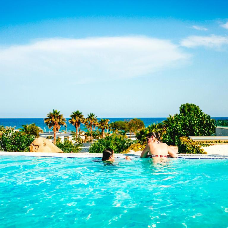 a group of people swimming in a swimming pool at Alannia Els Prats in Montroig