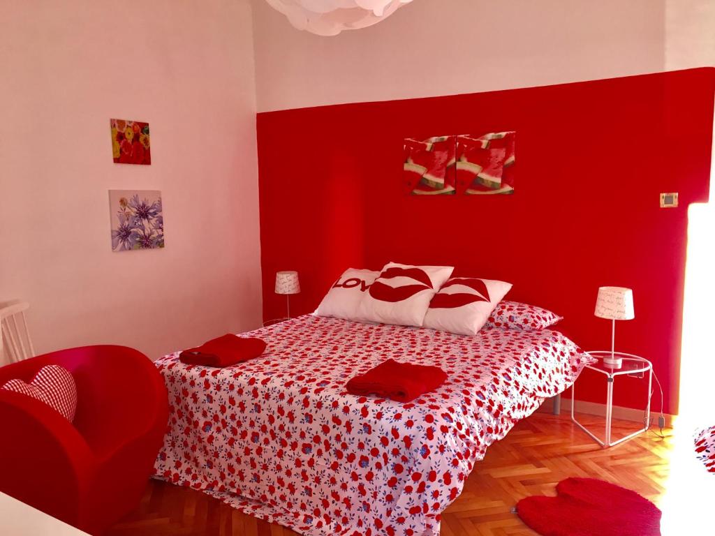 ein rotes Schlafzimmer mit einem Bett mit rotem Kopfteil in der Unterkunft Casa del Cucciolo in Triest