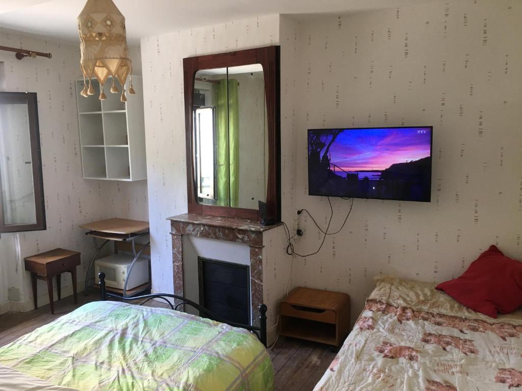 a bedroom with a bed and a tv on the wall at Suite parentale in Montargis