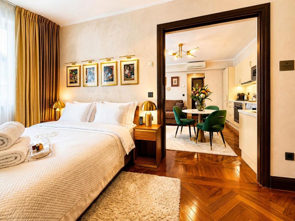 a bedroom with a large bed and a dining room at Victoriei Boutique Apartment in Bucharest