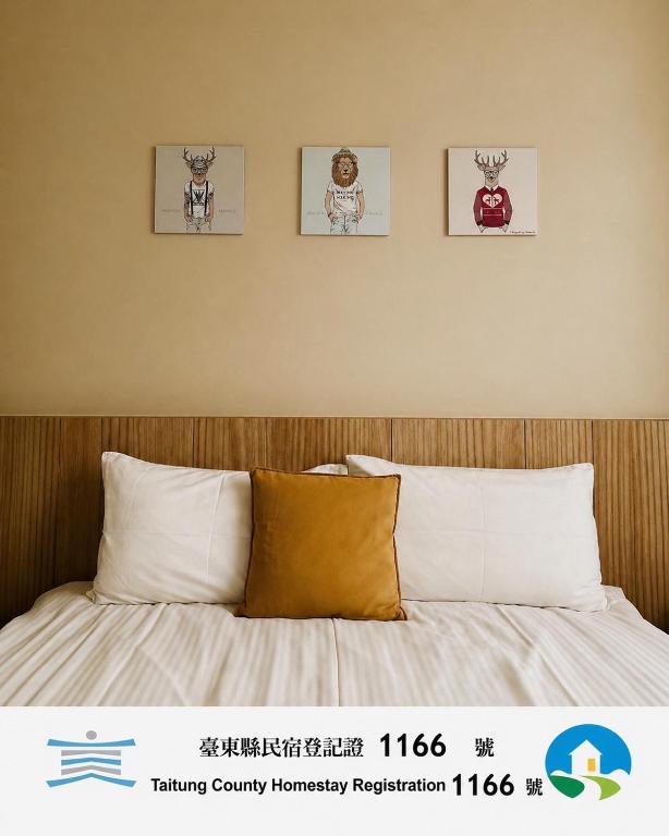 a bedroom with a bed with four pictures on the wall at 古栗Chestnut Guest House-可包棟民宿-民宿編號1166號 in Taitung City