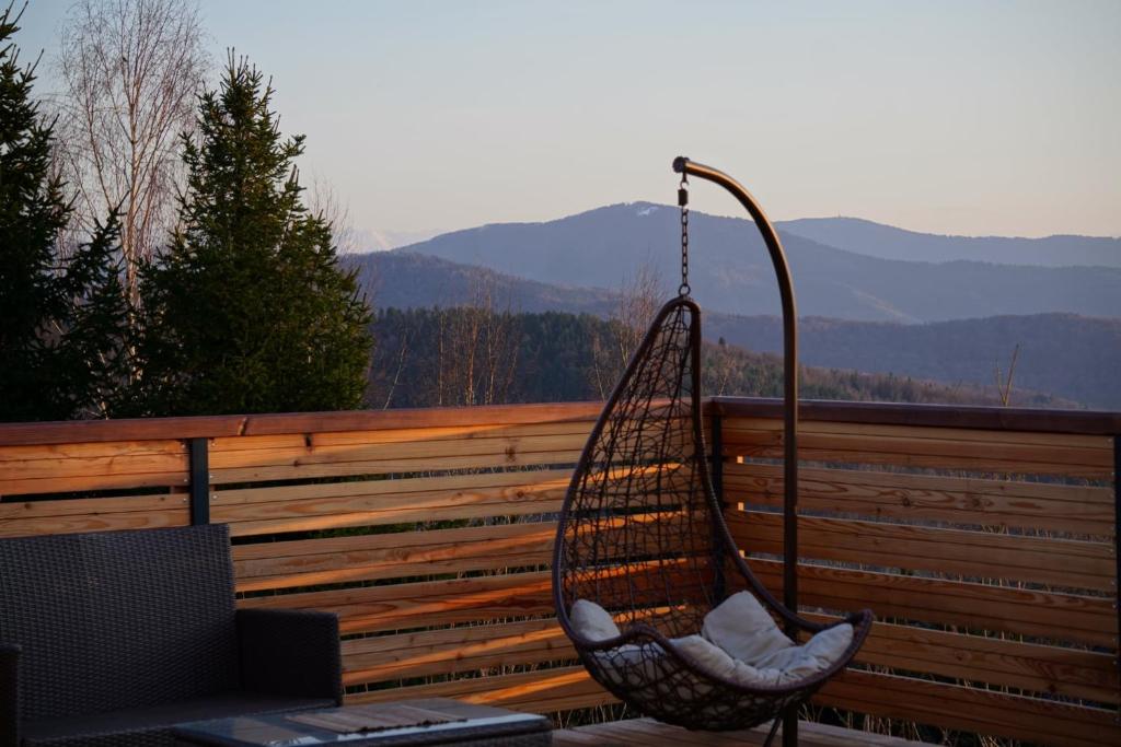 a swing on a porch with a view of mountains at Widokówka Kudłacze Dom z Jacuzzi i sauną na wyłączność in Pcim