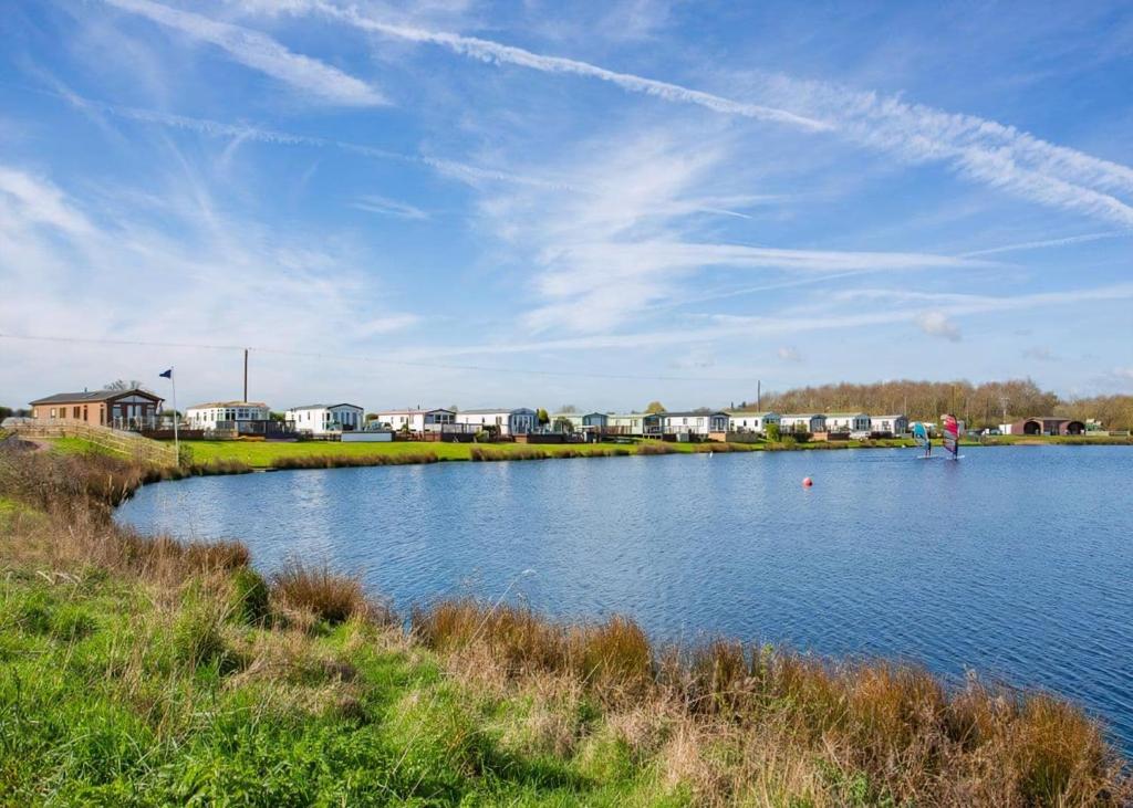 a large body of water with houses in the background at Croft Farm Water Park in Tewkesbury