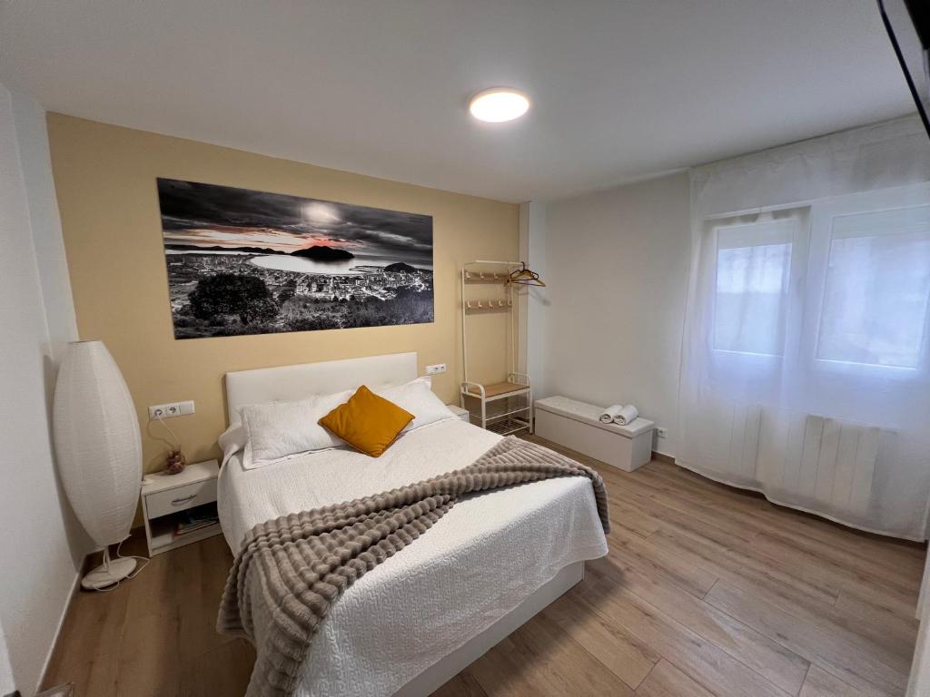 a bedroom with a bed and a painting on the wall at Apartamento Room Laredo in Laredo