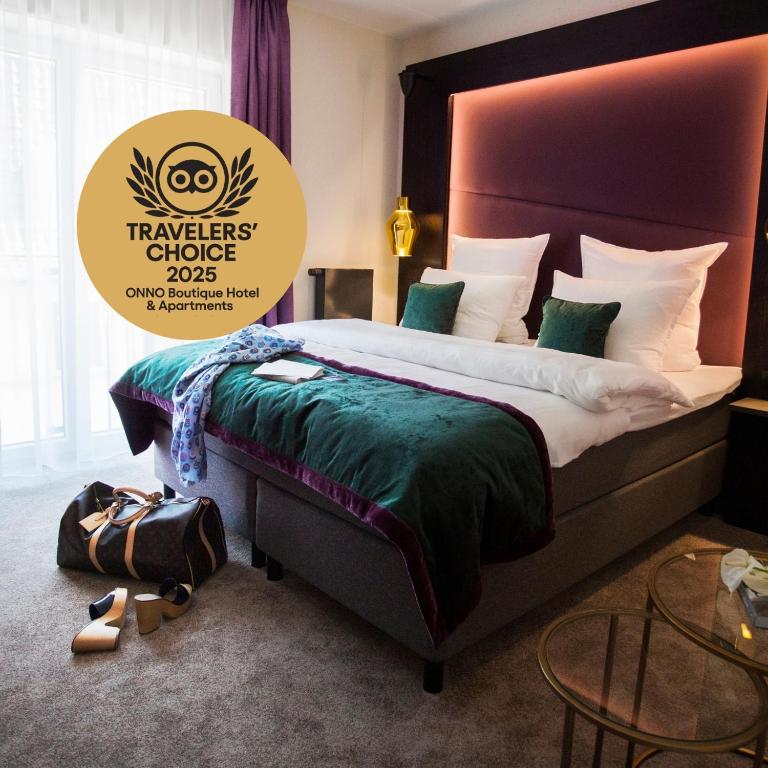 a bedroom with a large bed with a green comforter at ONNO Boutique Hotel & Apartments in Rendsburg