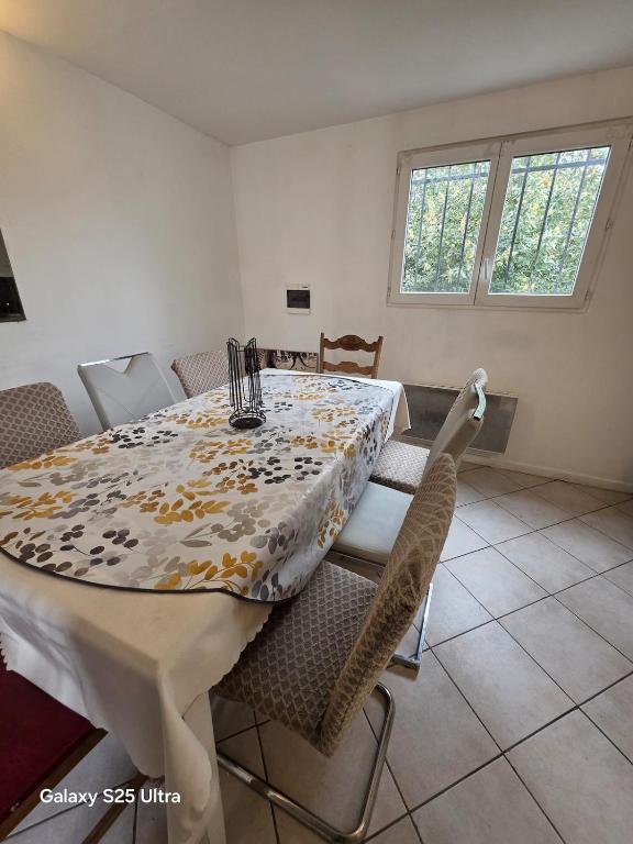 a dining room with a white table and chairs at PR2 - 2 Bedrooms and a Fully Equipped Kitchen in Le Blanc-Mesnil