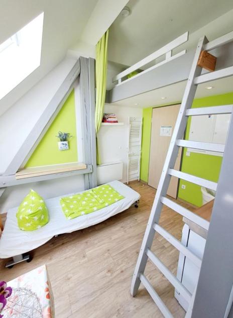 a bunk bed in a room with a ladder at Schullandheim Bautzen Burk nahe der Talsperre - Dachkammer deluxe in Bautzen