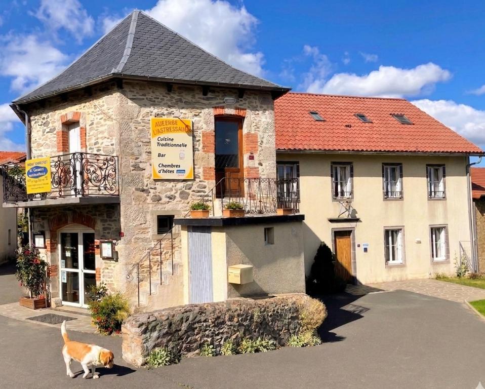 a dog standing in front of a building at Chambres d'hôtes de l'Auberge L'Astrassadou in Rézentières