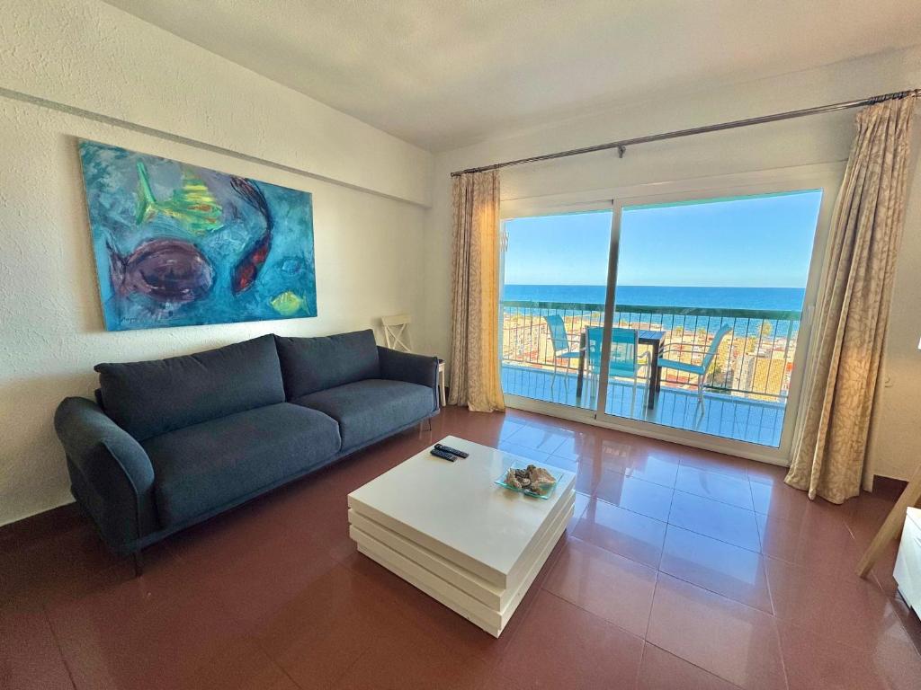 a living room with a couch and a view of the ocean at Marenostrum view in Playa Pobla de Farnals