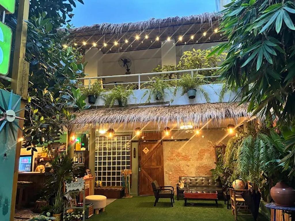 a garden with a house with a lot of plants at The Oasis on 8 Cozy Homestay & Café in Bangkok