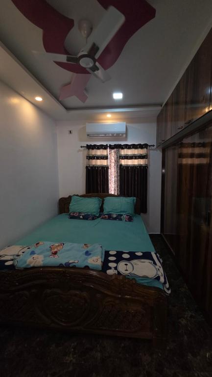a bedroom with a bed with a ceiling fan at Lucky garden inn in Chennai