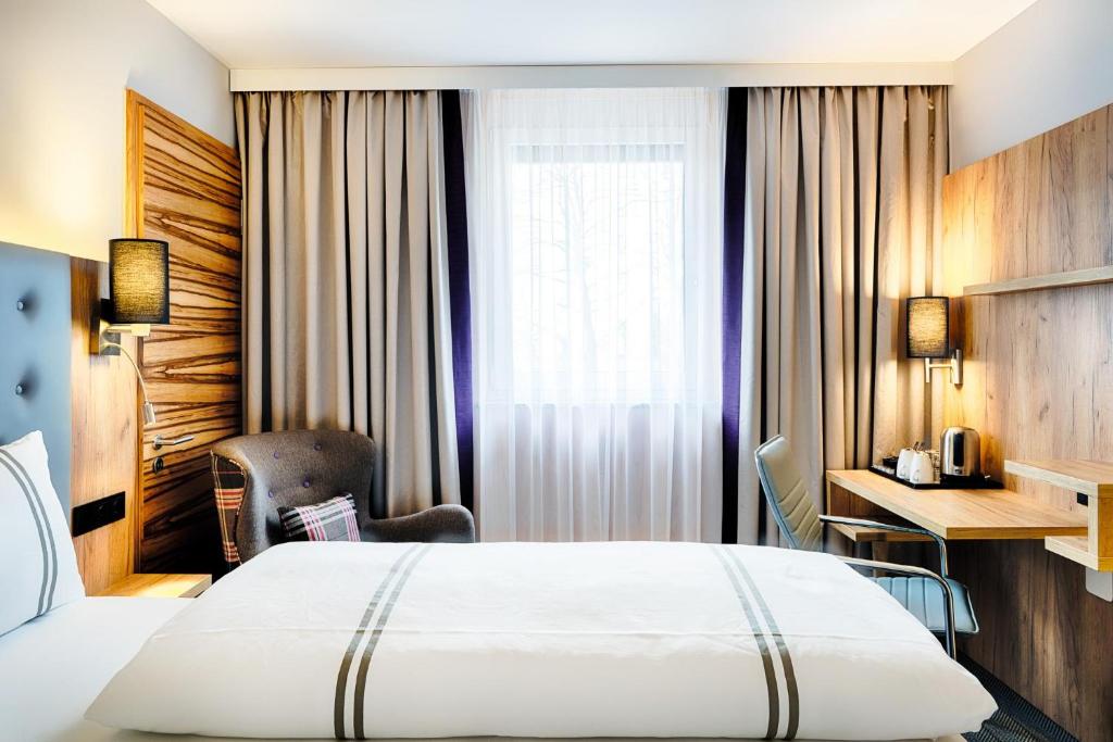 a hotel room with a bed and a desk at Premier Inn Lindau in Lindau