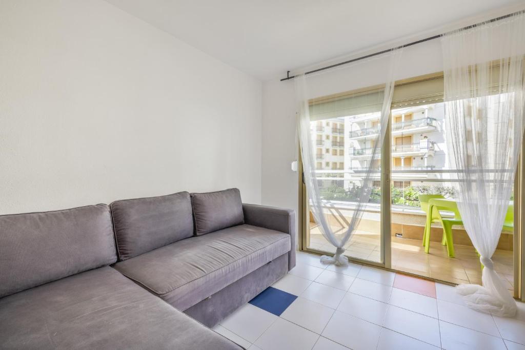 a living room with a couch and a large window at Resguardo en la playa in Calafell