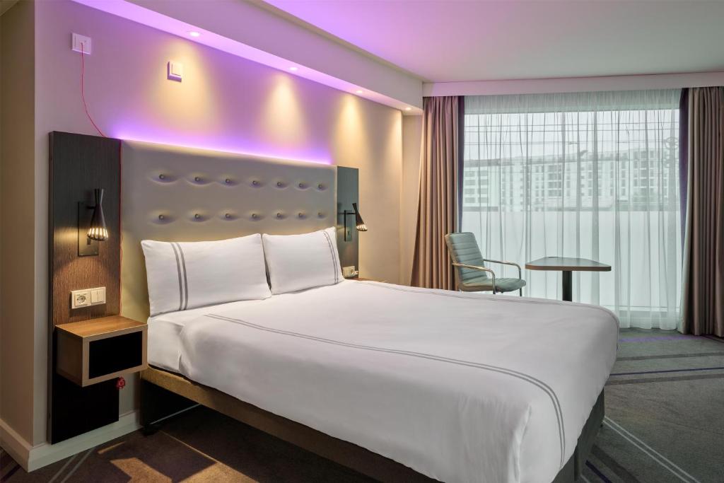 a hotel room with a large bed with a purple lighting at Premier Inn Stuttgart City Centre in Stuttgart