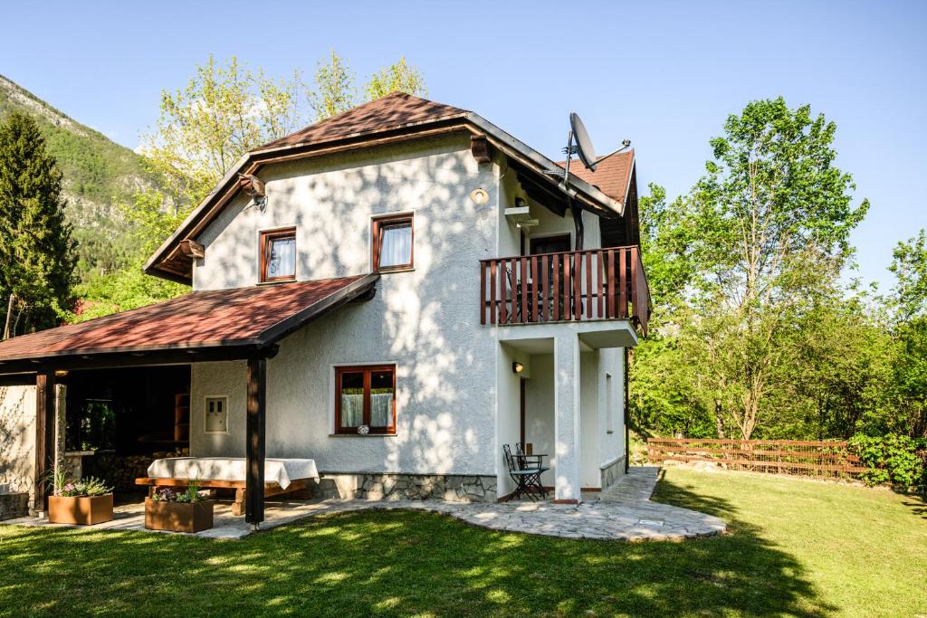 a white house with a balcony on a yard at Albatros in Bovec