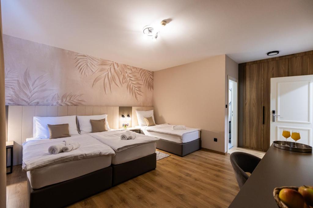 a hotel room with two beds and a couch at Hotel Klek in Ogulin