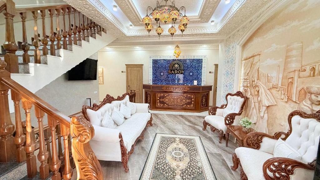 a living room with white furniture and a staircase at Saroy Khiva in Khiva
