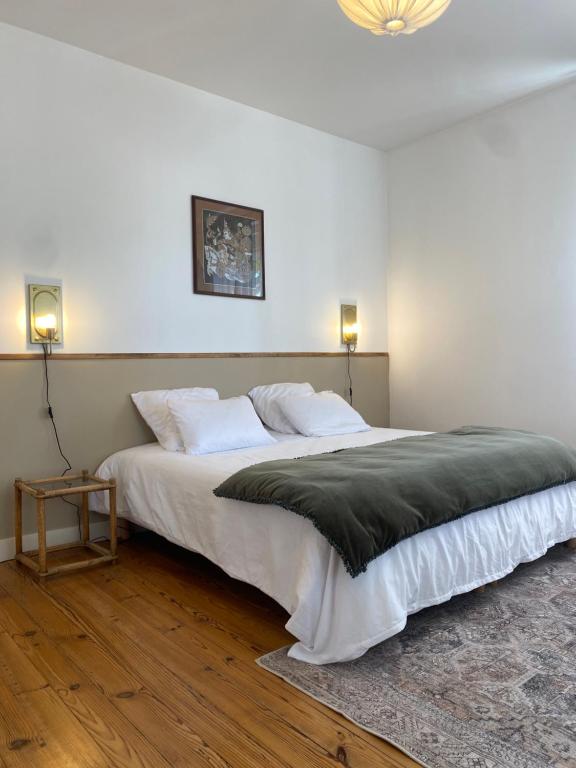 a bedroom with a large white bed with two lamps at Maison de vacances, centre ville Gambetta in La Teste-de-Buch