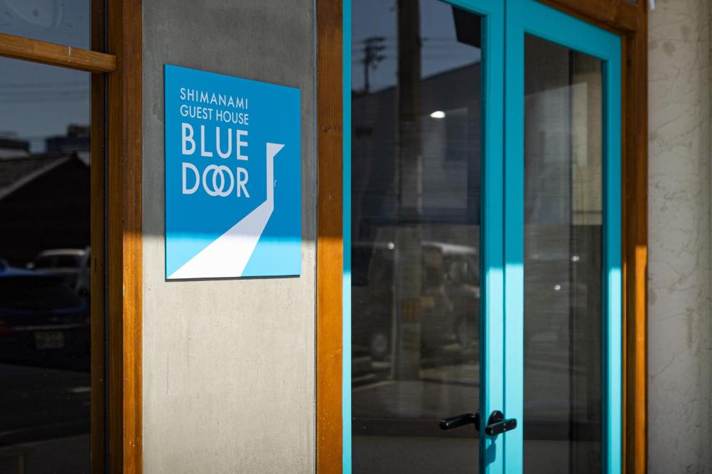 a blue door with a sign on it at Guest House BLUE DOOR in Imabari Railway Station