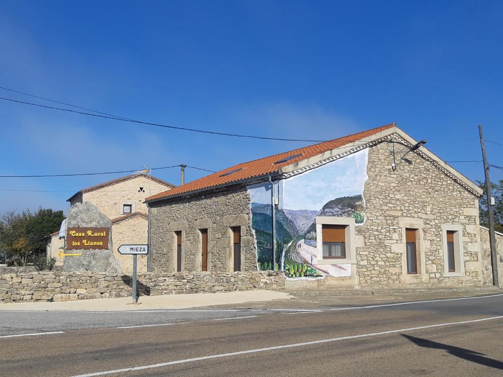 a building with a mural on the side of it at Alojamiento Turístico Río Uces in La Zarza de Pumareda