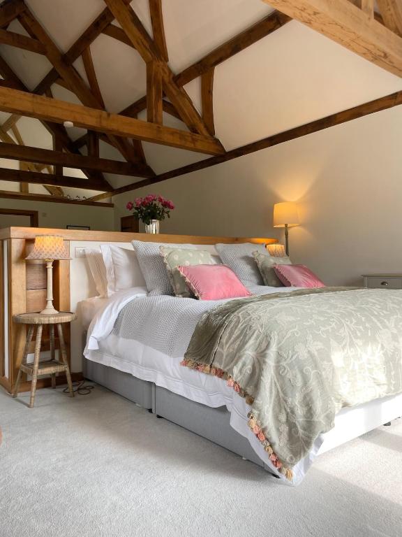 a bedroom with a large white bed with pink pillows at The Silver Suite at Manor Farm in Edenbridge