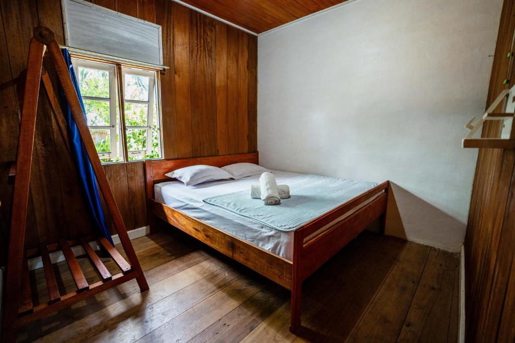 a small bedroom with a bed and a window at Likat Surf House in Tua Pejat