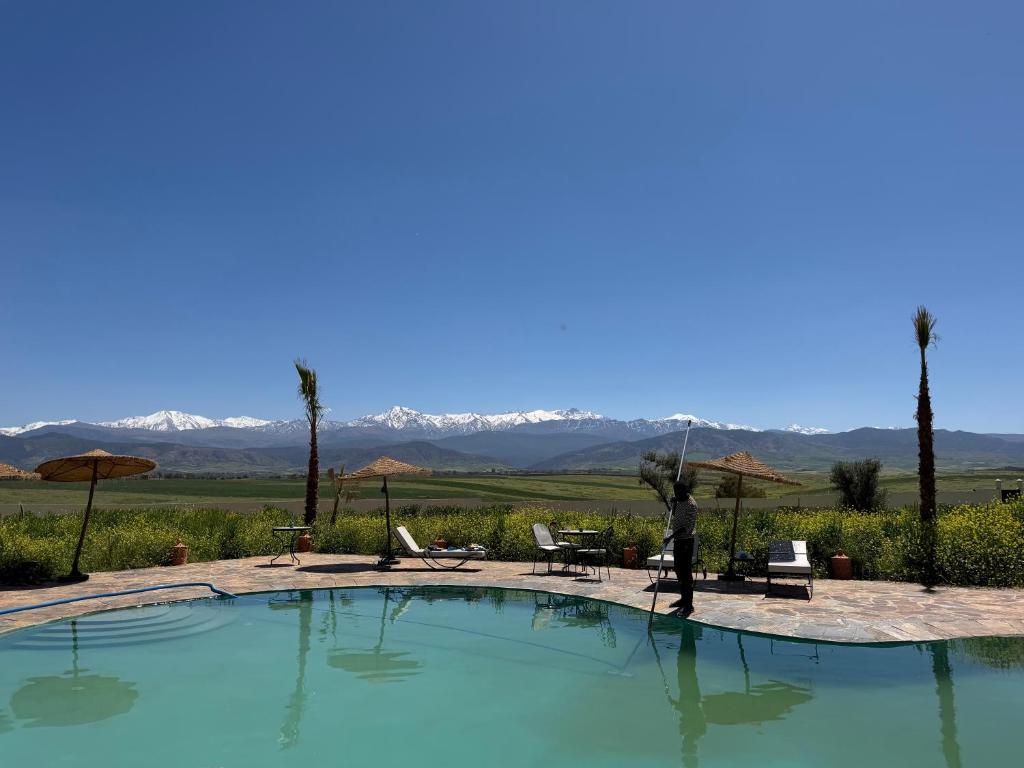 a person standing in front of a swimming pool at Dar Diyafa Marrakech in Maout